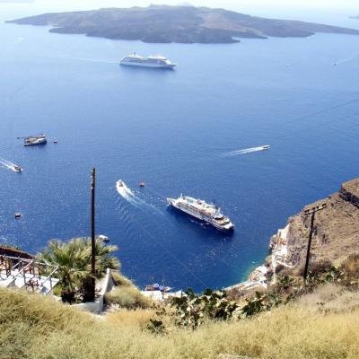 Blick von Fira runter zum Hafen und auf Kreuzfahrtschifffe und die Vulkaninsel Nea Kameni im Hintergrund